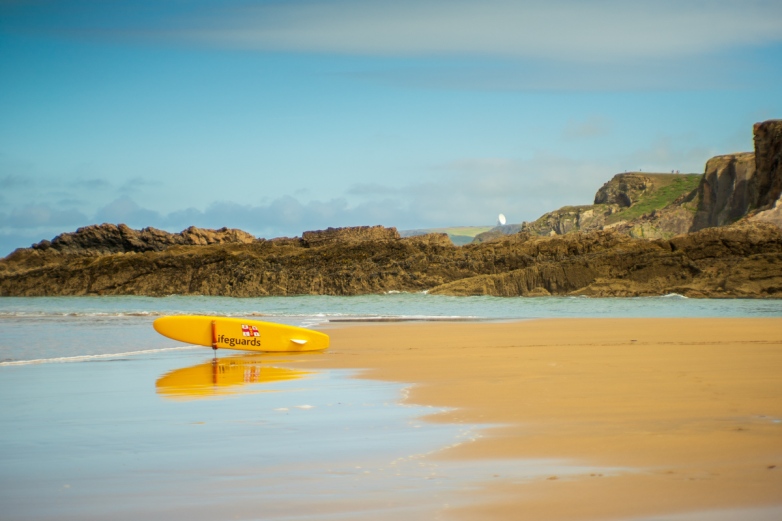 Lifeguard surfboard at Crooklets Beach, looking North with GCHQ Bude in the distance